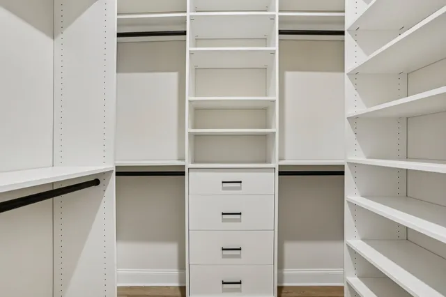 a view of walk in closet with empty racks