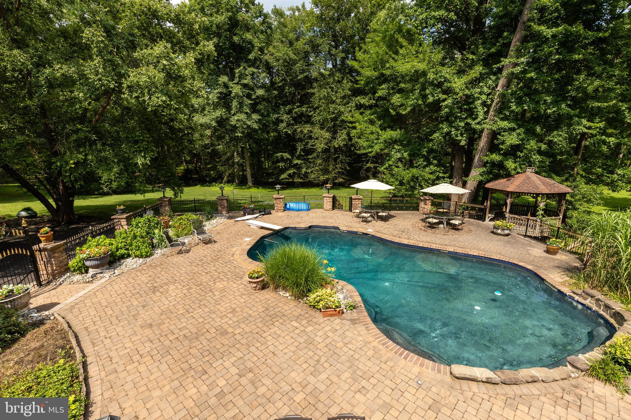 1733 Stocton Road Jenkintown, PA 19046 - Photo 123 of 149 a view of a swimming pool with lawn chairs under an umbrella