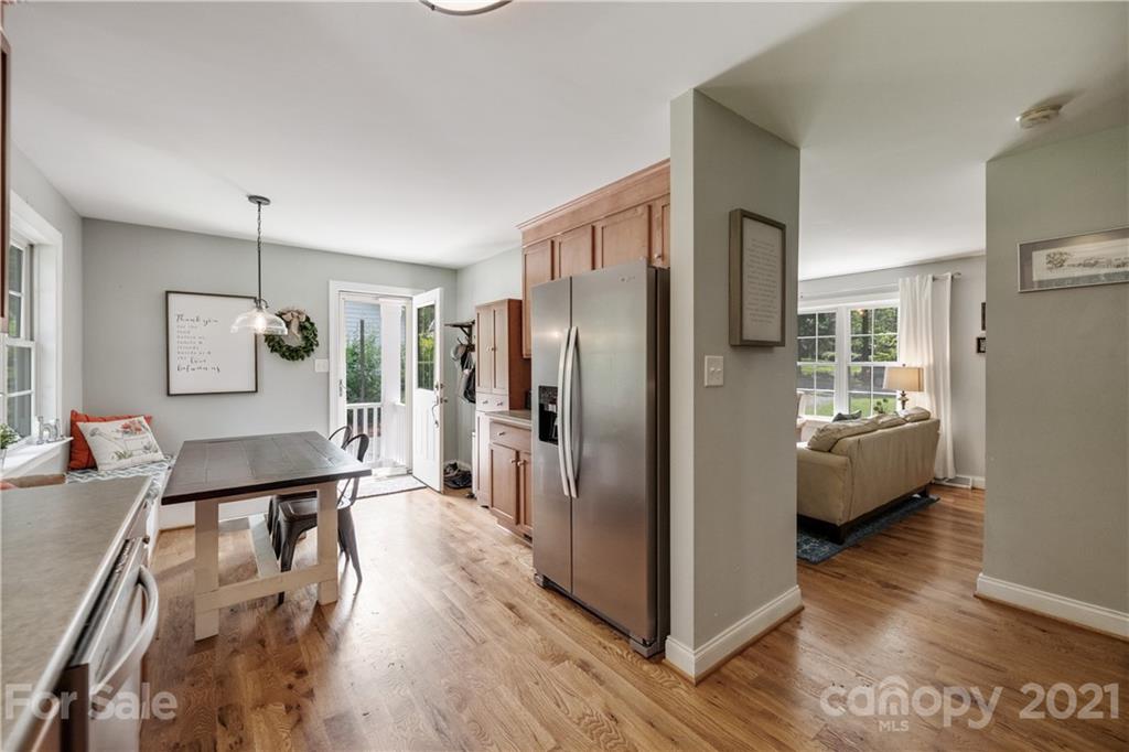 7324 Windyrush Road Charlotte, NC 28226 - Photo 11 of 27 a view of a kitchen with kitchen island a refrigerator wooden floor and a dining table