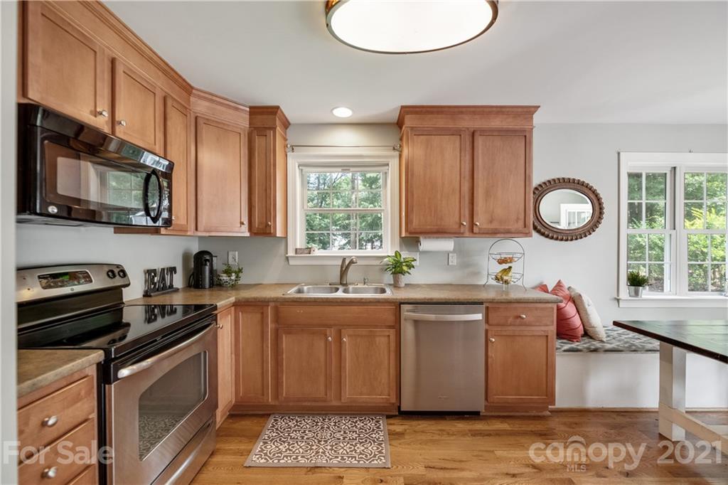 7324 Windyrush Road Charlotte, NC 28226 - Photo 6 of 27 a kitchen with stainless steel appliances granite countertop a sink a stove a microwave cabinets and a window