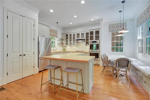 a room with stainless steel appliances kitchen island granite countertop furniture and a wooden floor