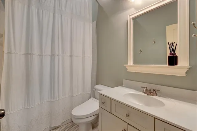 a bathroom with a granite countertop sink and a toilet