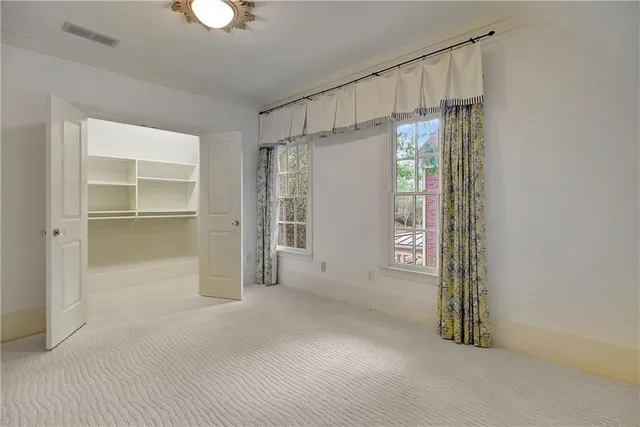 a view of an empty room with a fireplace and a window
