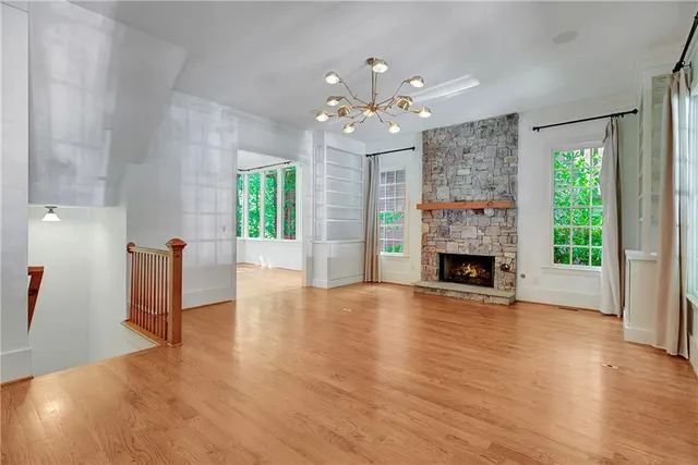 a view of a livingroom with wooden floor a fireplace and window