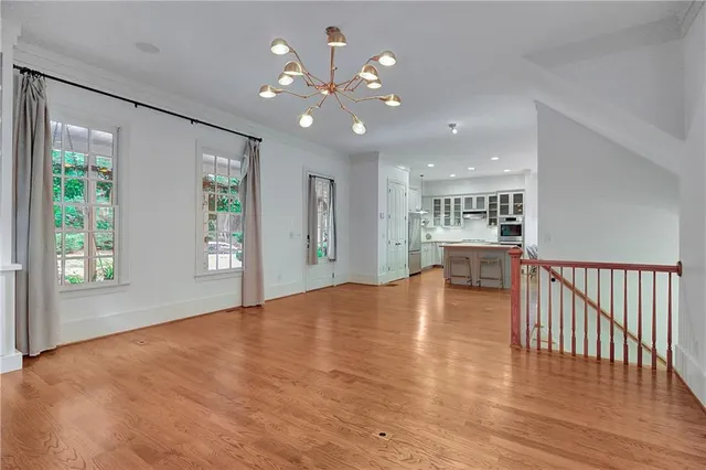 a view of an empty room with window and wooden floor