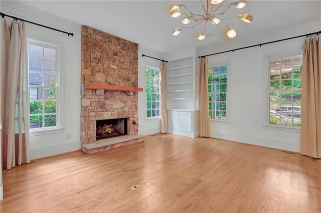 a view of an empty room with a window and fireplace