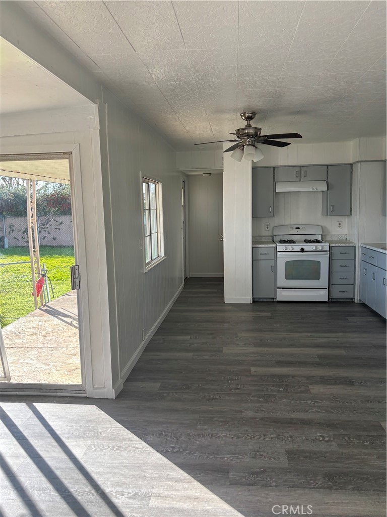 2499 East Gerard Avenue, Unit 32 Merced, CA 95341 - Photo 2 of 7 an empty room with wooden floor kitchen view and a window