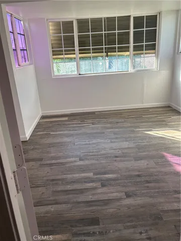 a view of door with wooden floor and windows