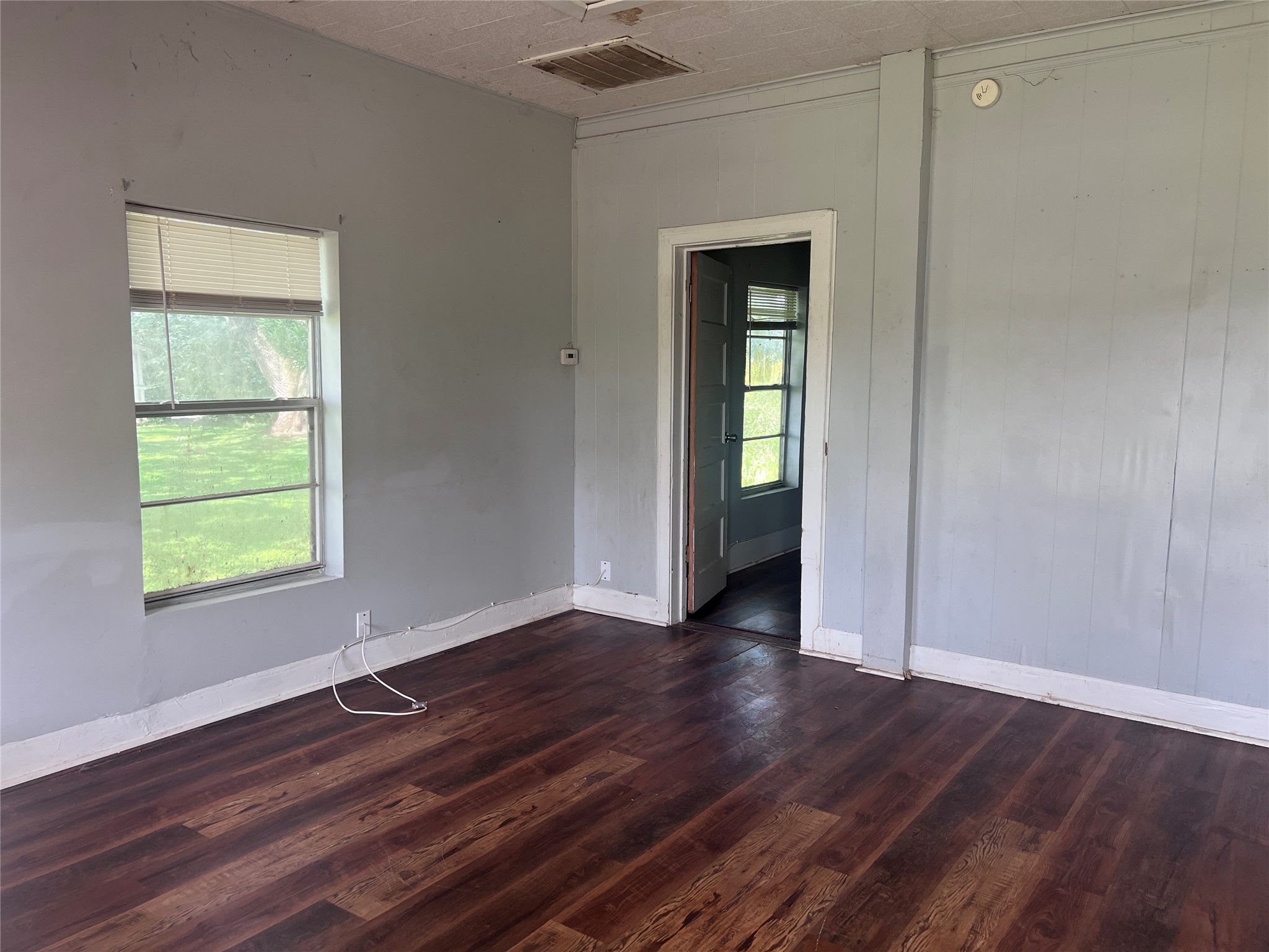 613 Harrison Lane Wharton, TX 77488 - Photo 3 of 10 an empty room with wooden floor closet and windows