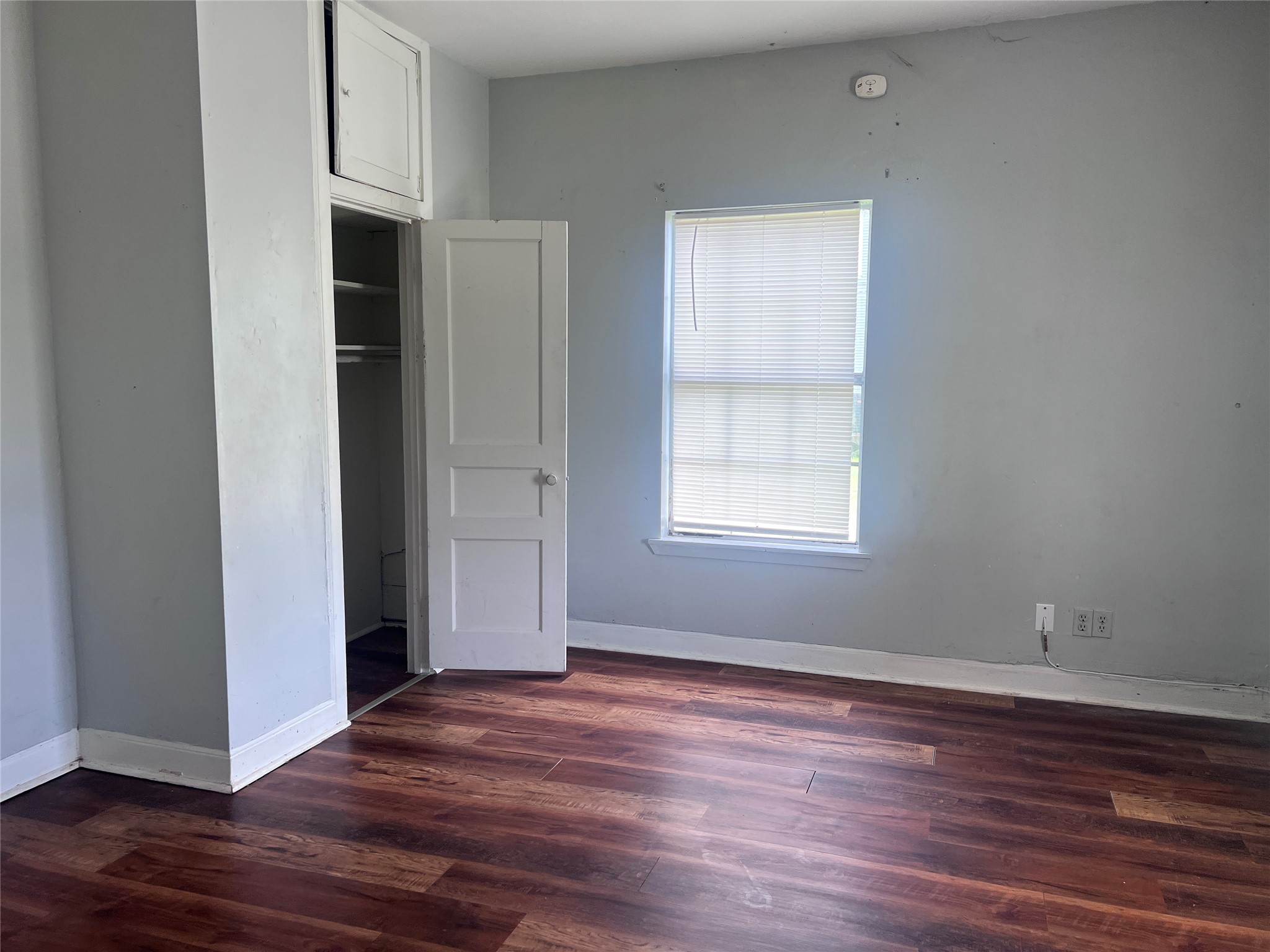 613 Harrison Lane Wharton, TX 77488 - Photo 4 of 10 an empty room with wooden floor and windows