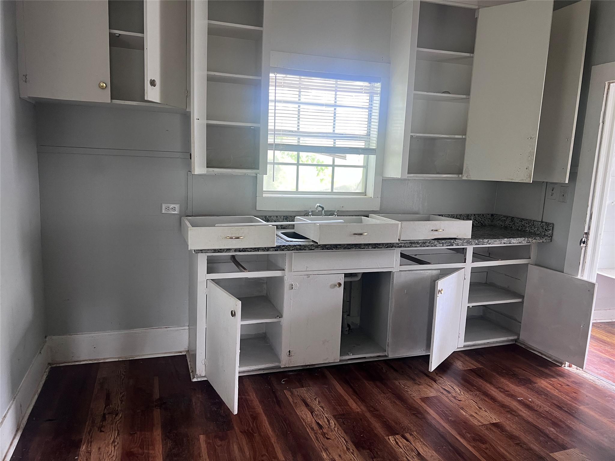613 Harrison Lane Wharton, TX 77488 - Photo 7 of 10 a kitchen with stainless steel appliances granite countertop a sink stove a sink and dishwasher with wooden floor