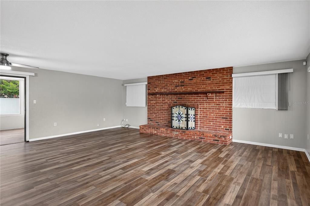 11 Reyes Road DeLand, FL 32724 - Photo 12 of 37 a view of an empty room with wooden floor and a fireplace