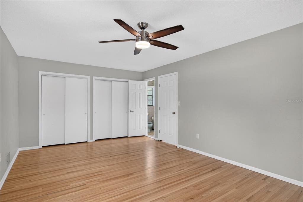 11 Reyes Road DeLand, FL 32724 - Photo 22 of 37 a view of an empty room with wooden floor and a ceiling fan