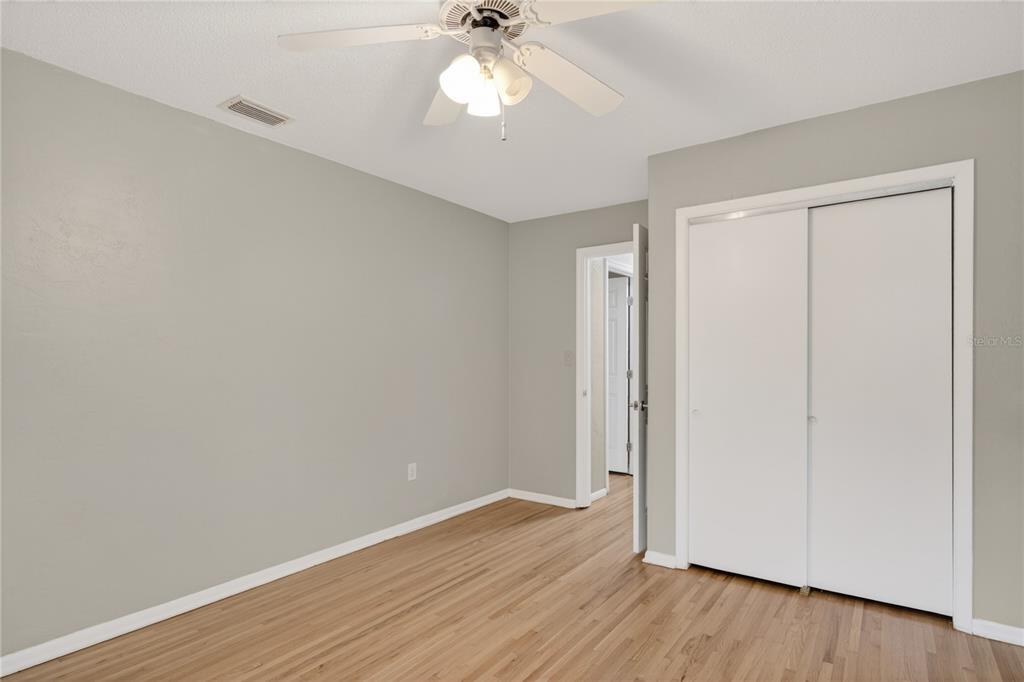 11 Reyes Road DeLand, FL 32724 - Photo 26 of 37 an empty room with wooden floor fan and windows
