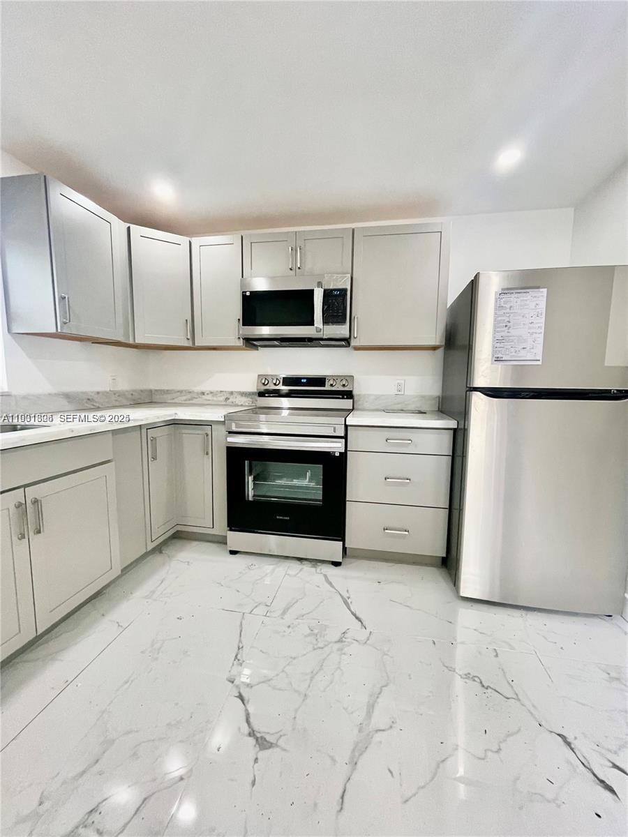 a kitchen with stainless steel appliances granite countertop a stove a sink and a refrigerator