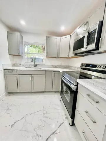 a kitchen with stainless steel appliances granite countertop a sink and a stove