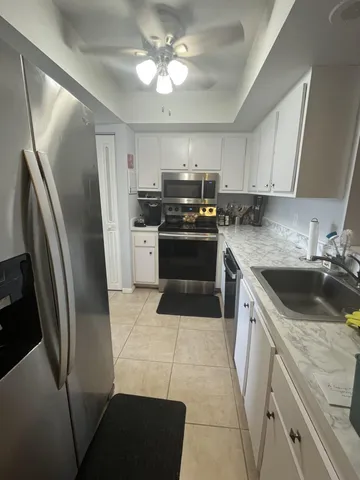 a kitchen with stainless steel appliances granite countertop a refrigerator a stove and a sink