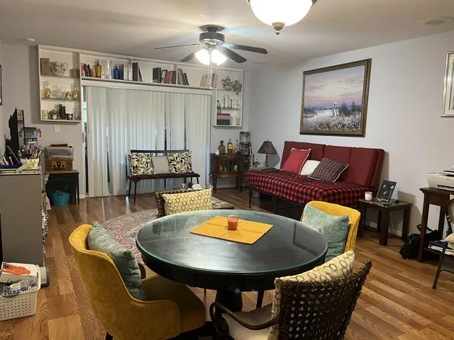 a living room with furniture a chandelier and a dining table