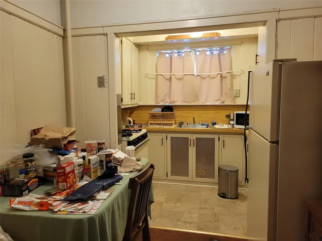 a room with stainless steel appliances granite countertop a refrigerator and a sink