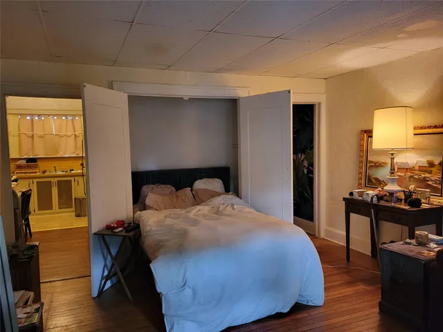 a bedroom with a bed and wooden floor
