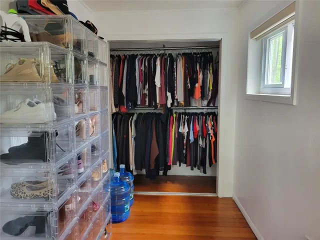 a view of walk in closet with clothes and shoes