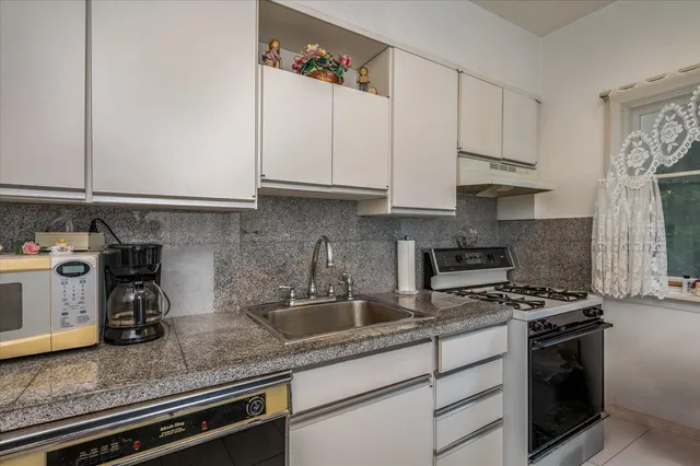 a kitchen with stainless steel appliances granite countertop a sink a stove and a granite counter tops