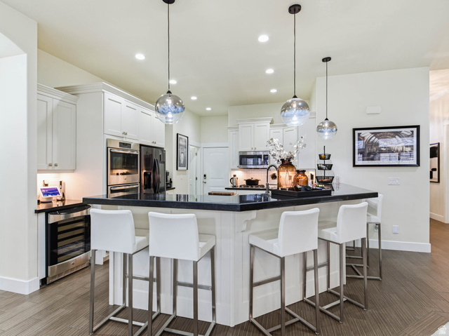 1154 Sunset Dunes Way Draper, UT 84020 - Photo 15 of 50 Kitchen featuring a breakfast bar, backsplash, white cabinets, wine cooler, and hanging light fixtures