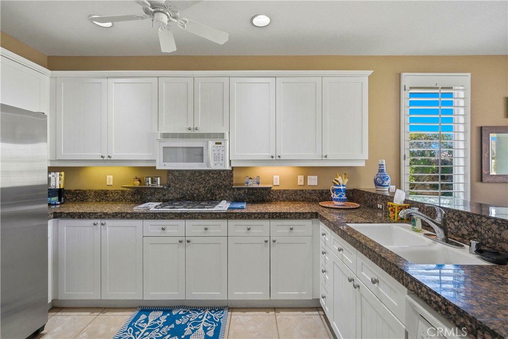 241 Via Martelli Rancho Mirage, CA 92270 - Photo 15 of 37 a kitchen with granite countertop a sink a stove and cabinets
