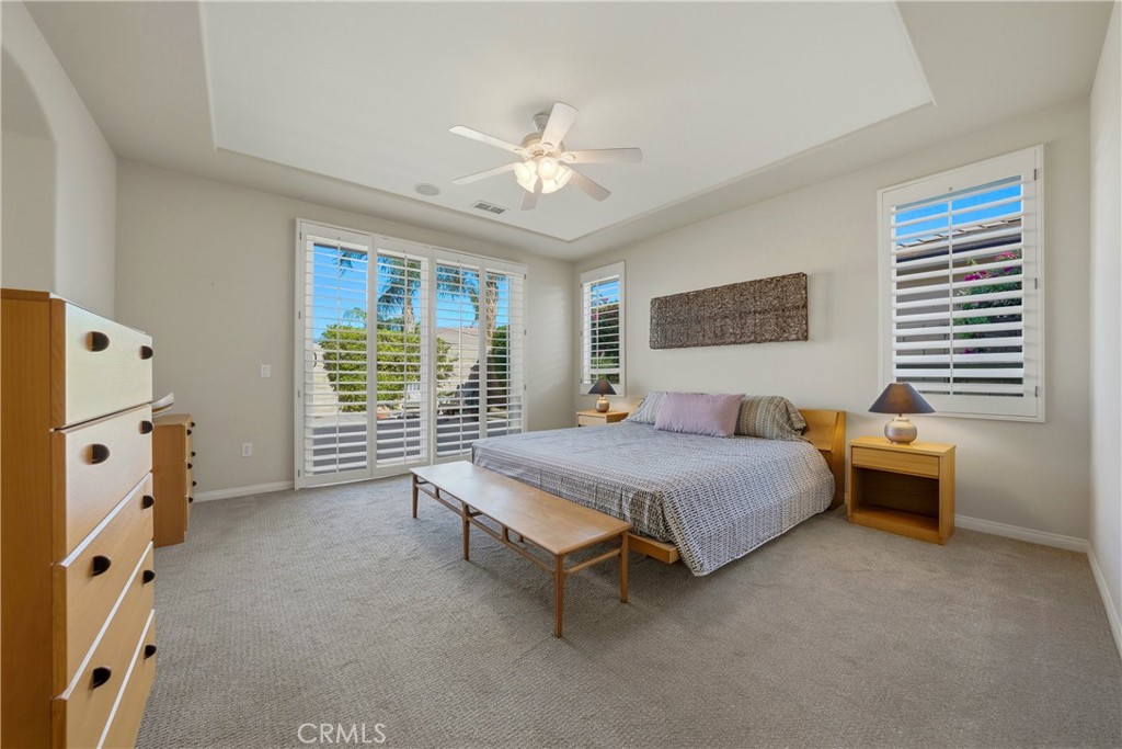 241 Via Martelli Rancho Mirage, CA 92270 - Photo 20 of 37 a spacious bedroom with a bed and a chandelier