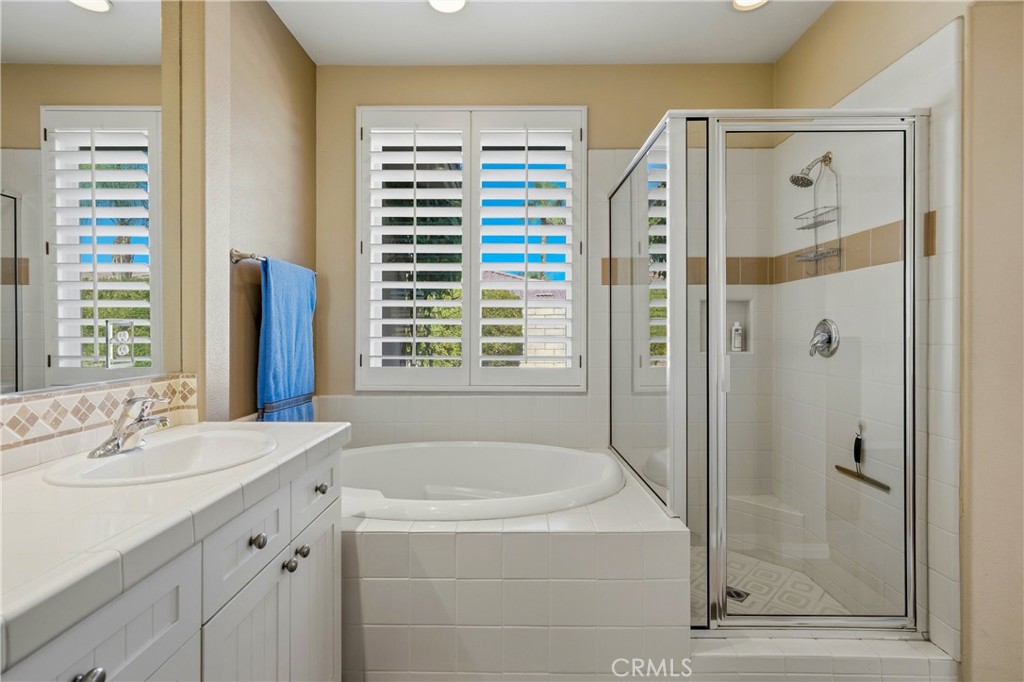 241 Via Martelli Rancho Mirage, CA 92270 - Photo 24 of 37 a bathroom with a granite countertop sink a shower and a mirror