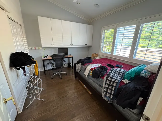 a view of a street with wooden fence next to a large tree
