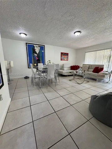 a living room with furniture a computer on the desk and chair
