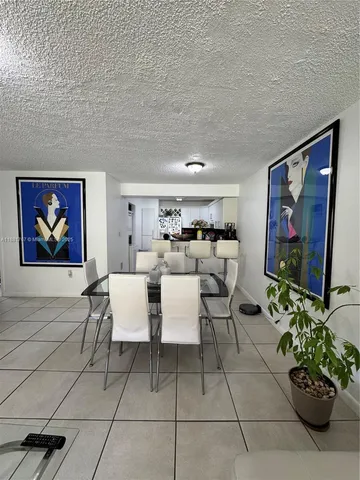 a living room with couches a coffee table and a painting on the wall
