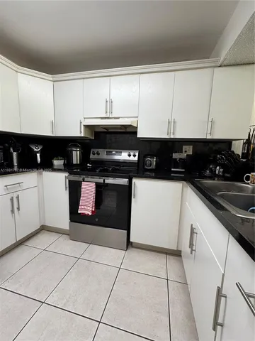 a kitchen with a sink a stove and cabinets