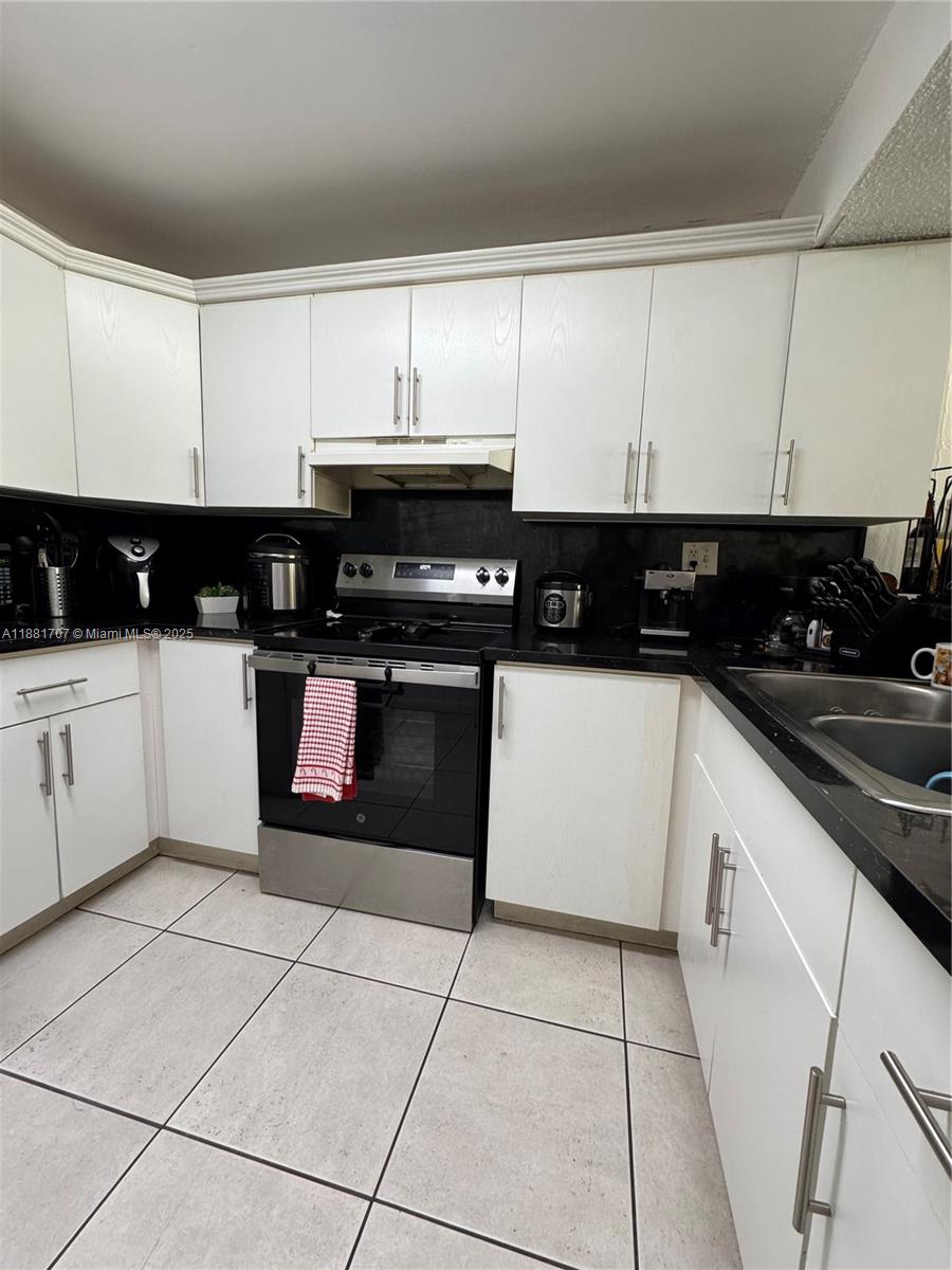 15480 Southwest 82nd Lane, Unit 228 Miami, FL 33193 - Photo 10 of 18 a kitchen with a sink a stove and cabinets