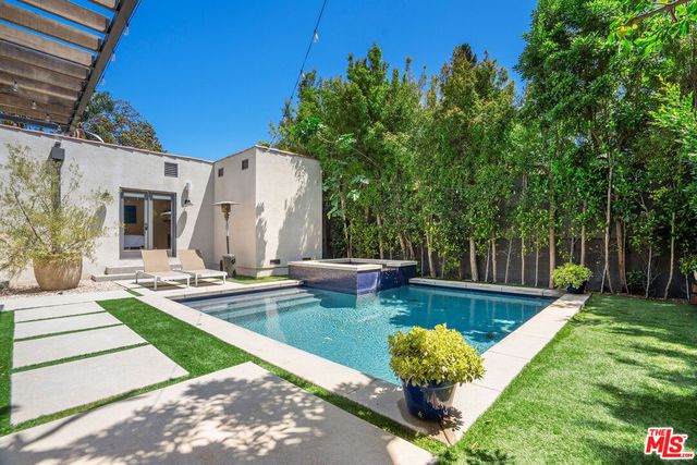 a view of a house with pool fire pit and a big yard