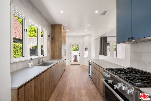 a large kitchen with stainless steel appliances a large window in it