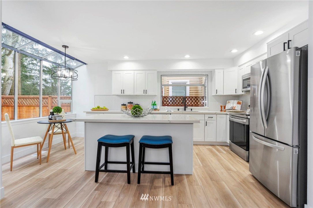 12715 Northeast 200th Place Bothell, WA 98011 - Photo 7 of 18 a kitchen with white cabinets and stainless steel appliances
