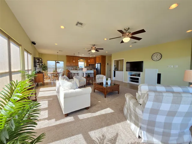 a living room with furniture a flat screen tv and a clock