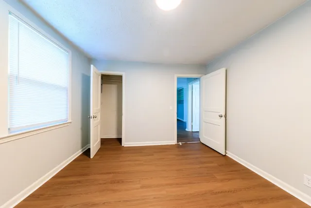 a view of an empty room with wooden floor