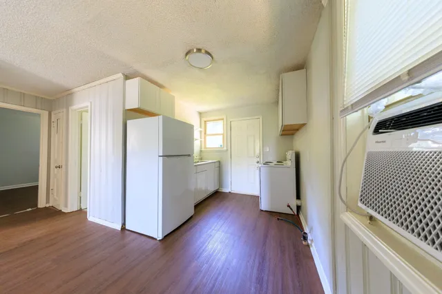 a view of a kitchen with wooden floor and electronic appliances