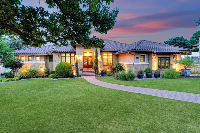 a front view of a house with a yard and trees