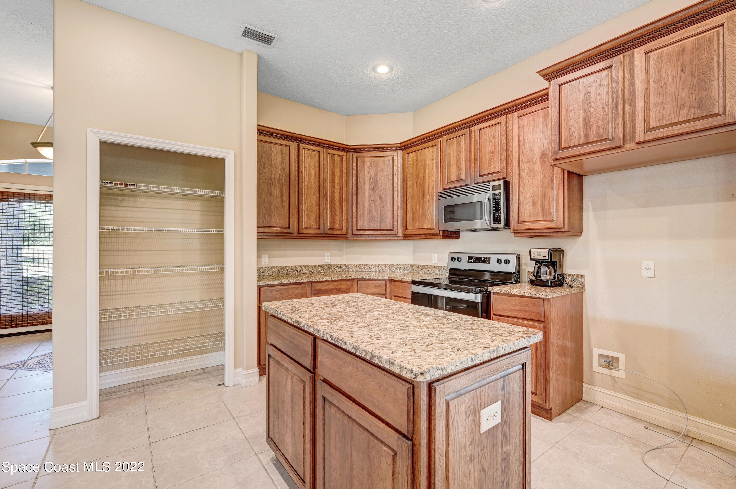 2185 Windbrook Drive Palm Bay, FL 32909 - Photo 37 of 61 a kitchen with granite countertop a stove and a refrigerator