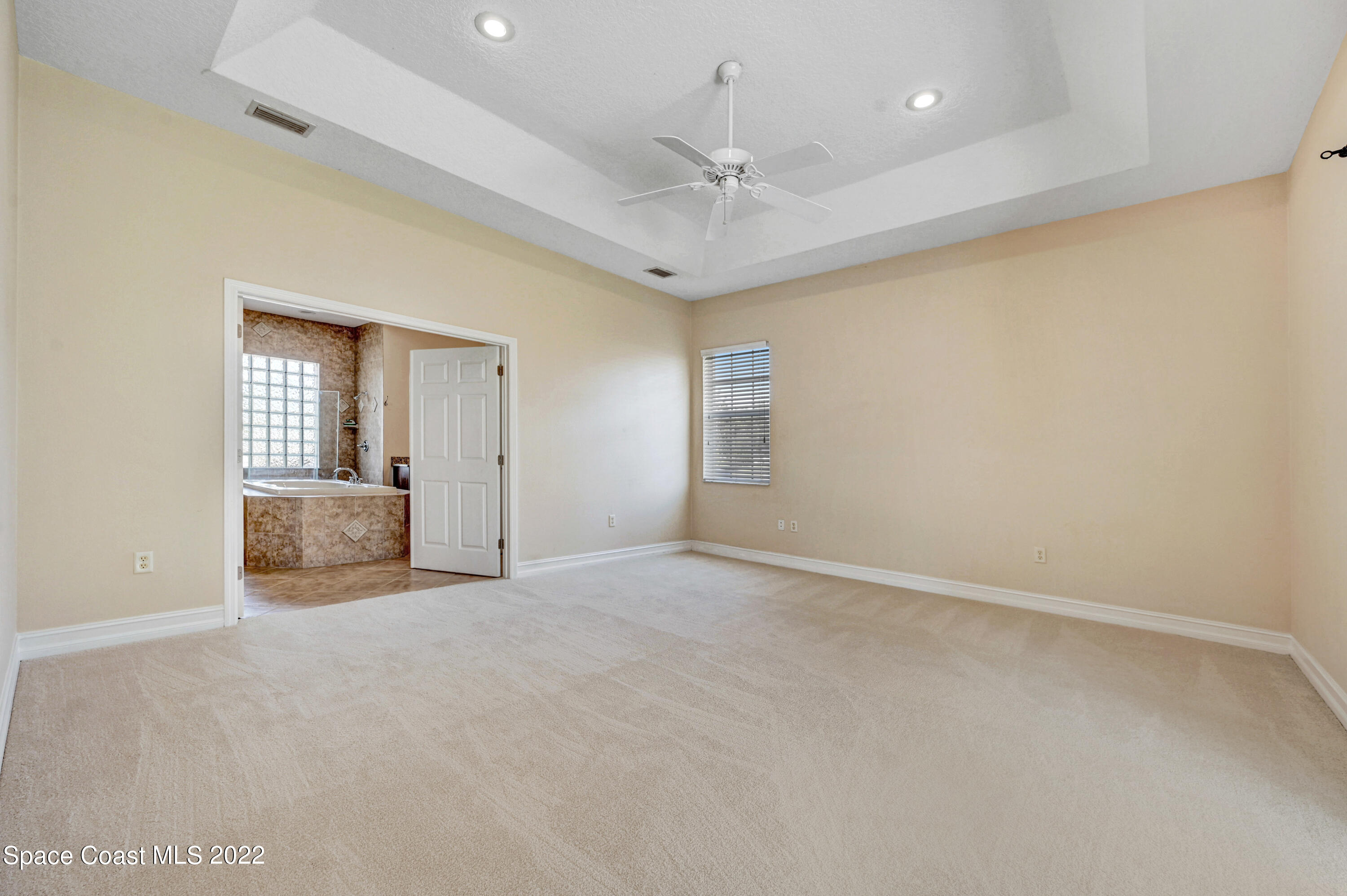 2185 Windbrook Drive Palm Bay, FL 32909 - Photo 46 of 61 an empty room with a large mirror and a ceiling fan