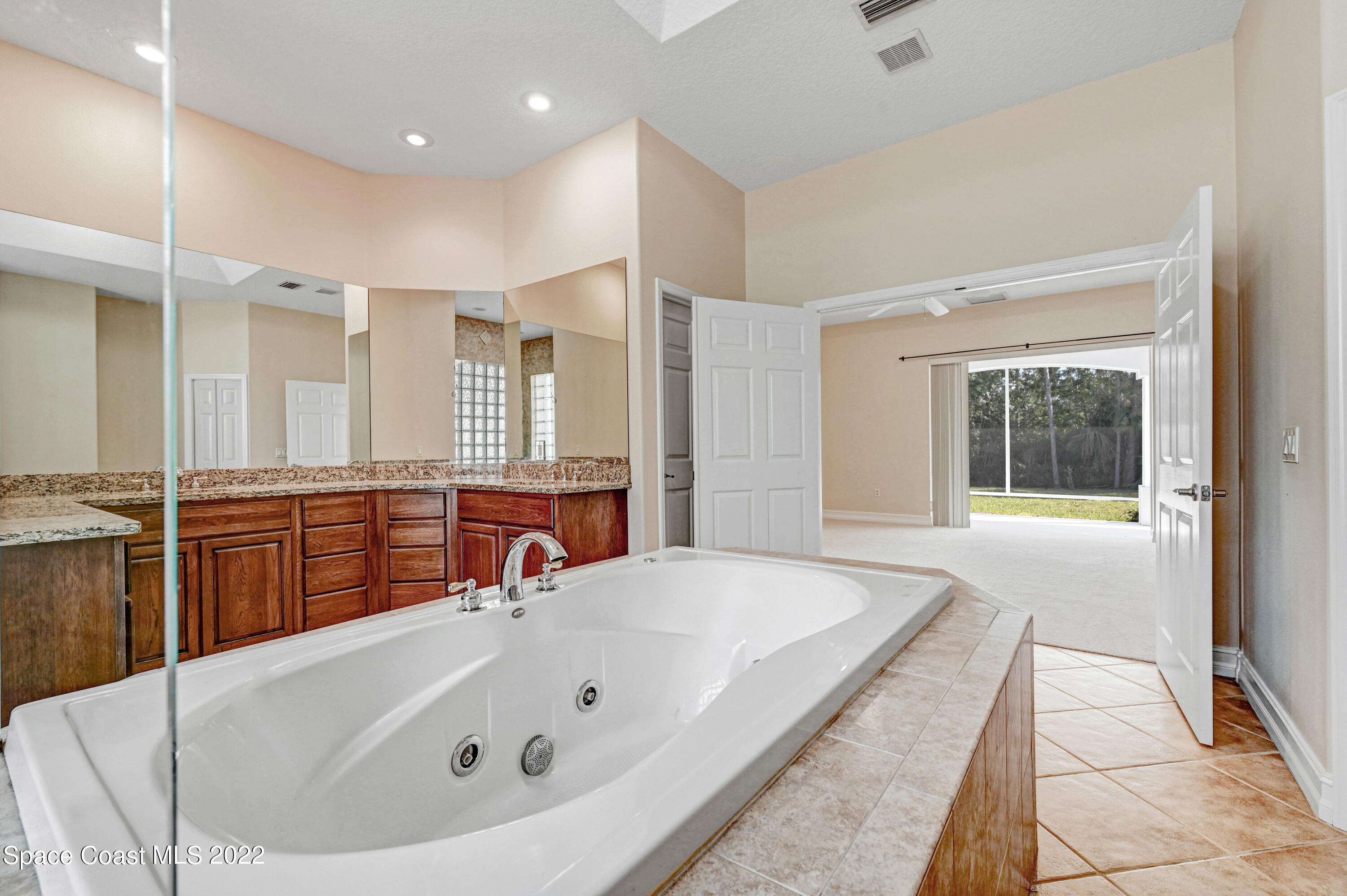 2185 Windbrook Drive Palm Bay, FL 32909 - Photo 51 of 61 a bathroom with a tub a sink and a large mirror