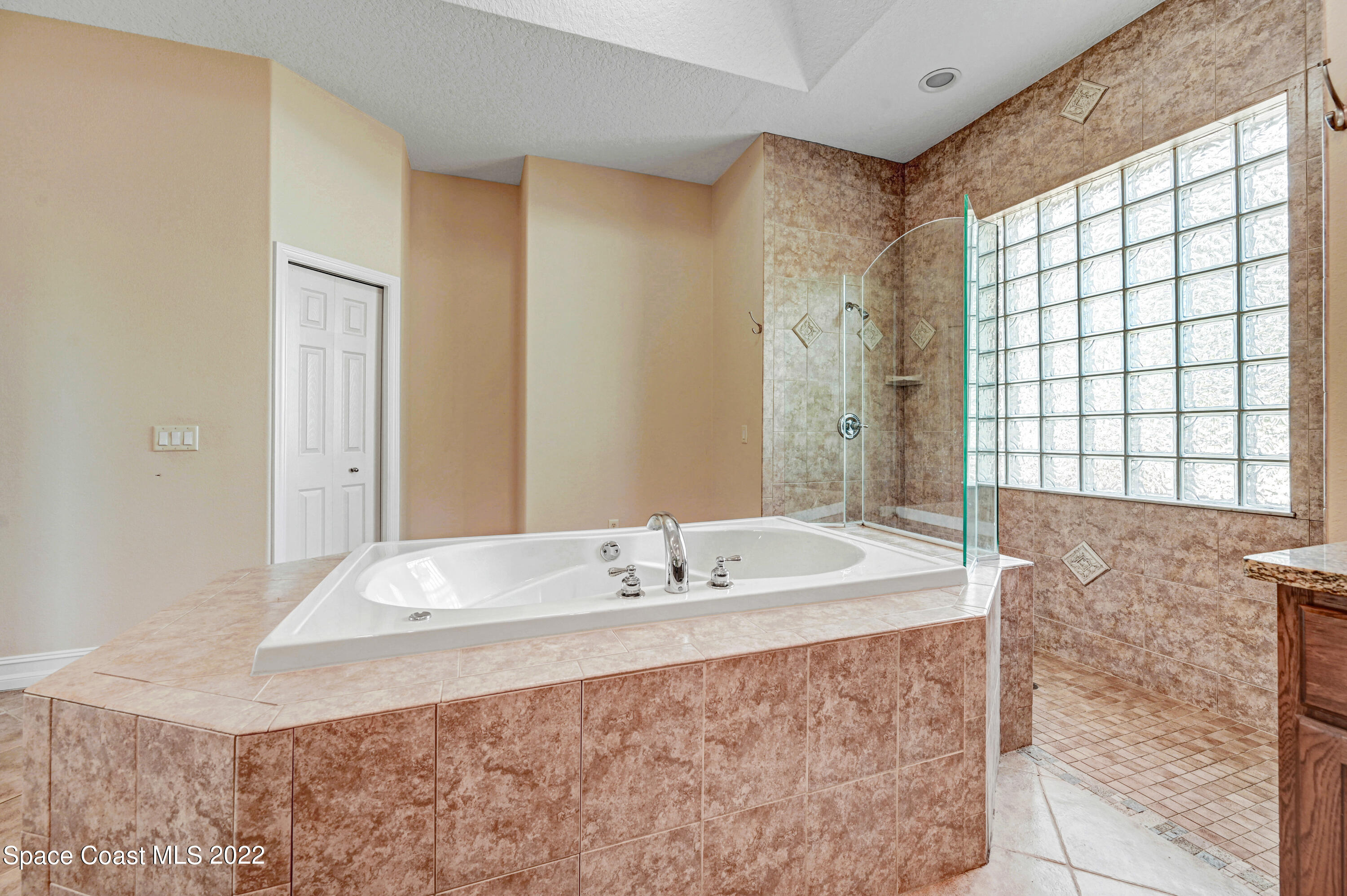 2185 Windbrook Drive Palm Bay, FL 32909 - Photo 53 of 61 a bathroom with a granite countertop sink a large mirror and a bathtub