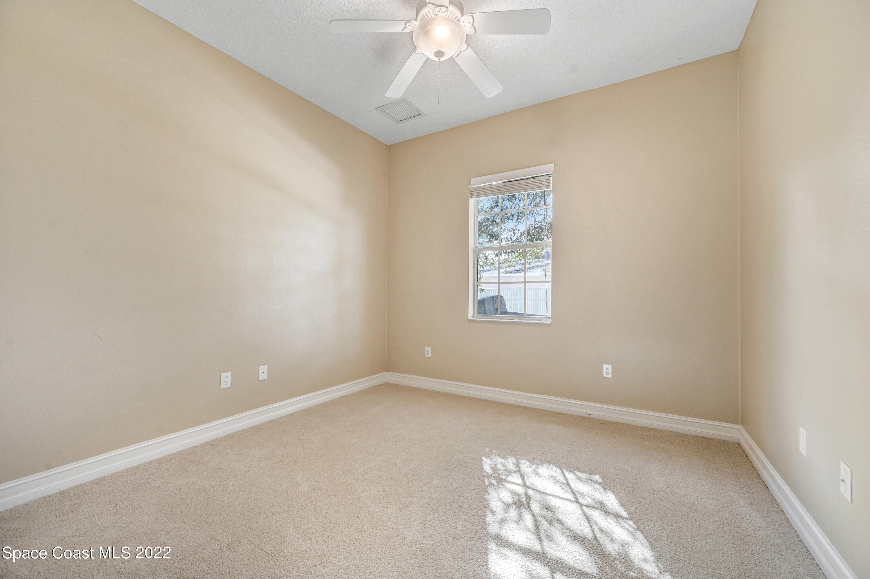 2185 Windbrook Drive Palm Bay, FL 32909 - Photo 55 of 61 an empty room with a chandelier fan and windows
