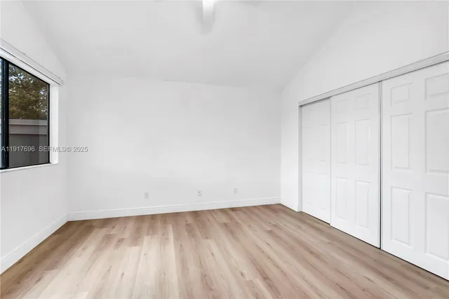 a bedroom with a large bed and a potted plant
