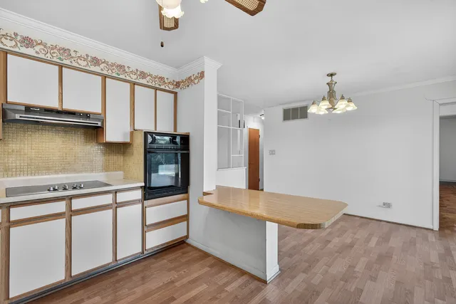 a kitchen with kitchen island a counter space a sink appliances and cabinets