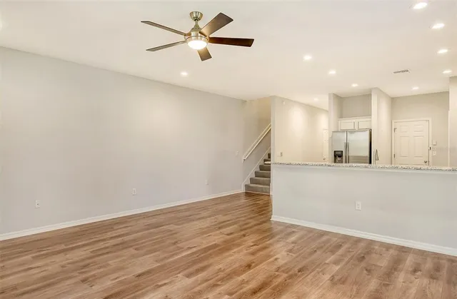 an empty space with wooden floor and a ceiling fan